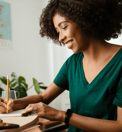 smiling female writing in her notebook