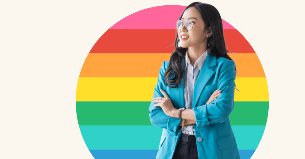 young professional person standing in front of rainbow coloured background